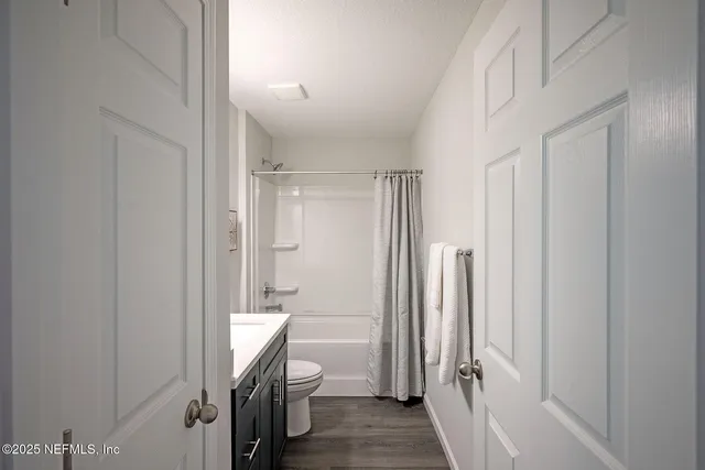 a bathroom with a granite countertop sink toilet a shower and a mirror