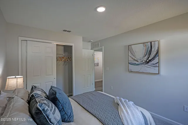 a bedroom with a bed and a painting on the wall