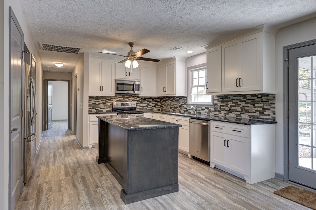 300 Garrison Branch Road Cottontown, TN 37048 - Photo 16 of 50 a kitchen with stainless steel appliances granite countertop a stove and a sink