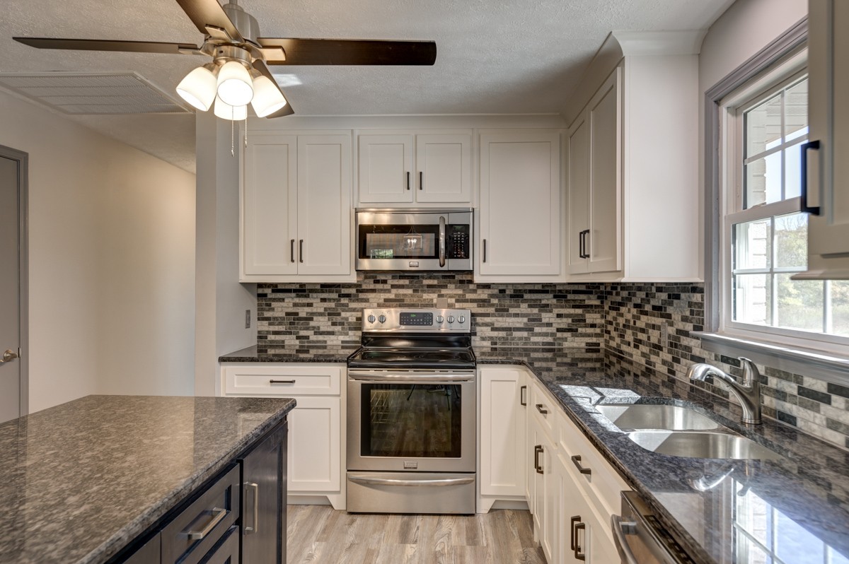 300 Garrison Branch Road Cottontown, TN 37048 - Photo 18 of 50 a kitchen with granite countertop stainless steel appliances a stove sink and microwave