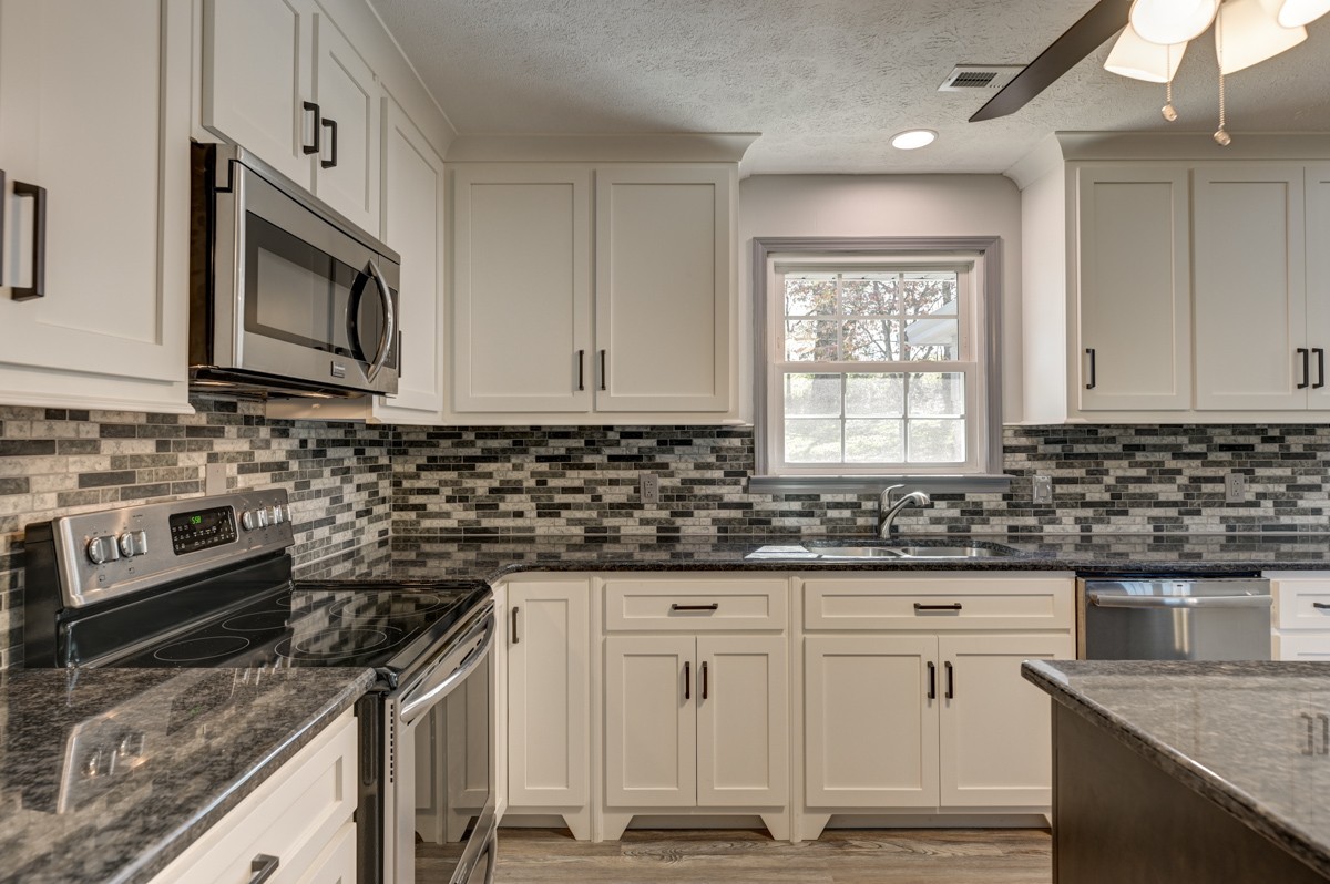 300 Garrison Branch Road Cottontown, TN 37048 - Photo 19 of 50 a kitchen with granite countertop white cabinets stainless steel appliances a sink and a window