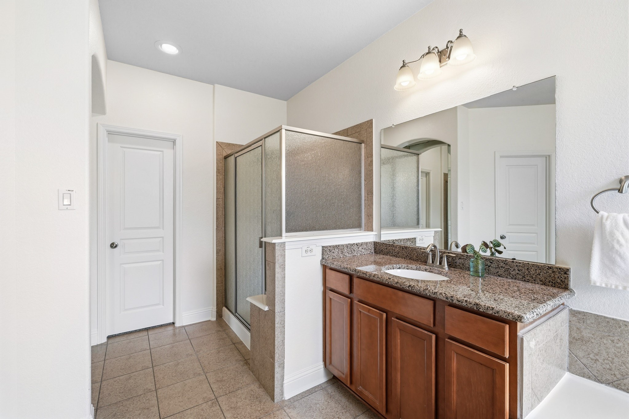 17610 Strackfield Lane Tomball, TX 77377 - Photo 26 of 50 The spacious walk-in shower features a built-in bench and elegant tile surround, creating a relaxing retreat, while the oversized closet with double hanging rods and dedicated shoe storage keeps everything impeccably organized.