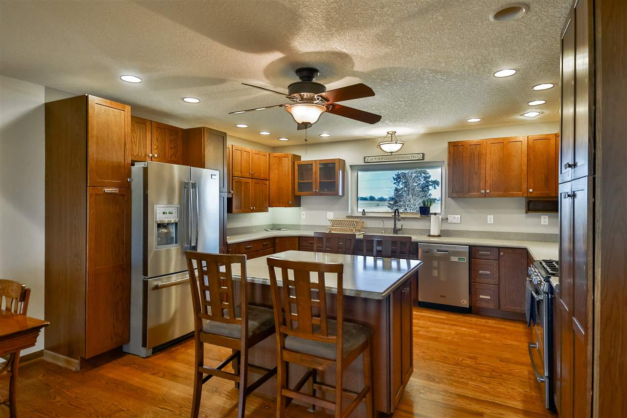 5776 Daysville Road Oregon, IL 61061 - Photo 13 of 34 a kitchen with stainless steel appliances granite countertop a refrigerator a stove a sink a dining table and chairs with wooden floor
