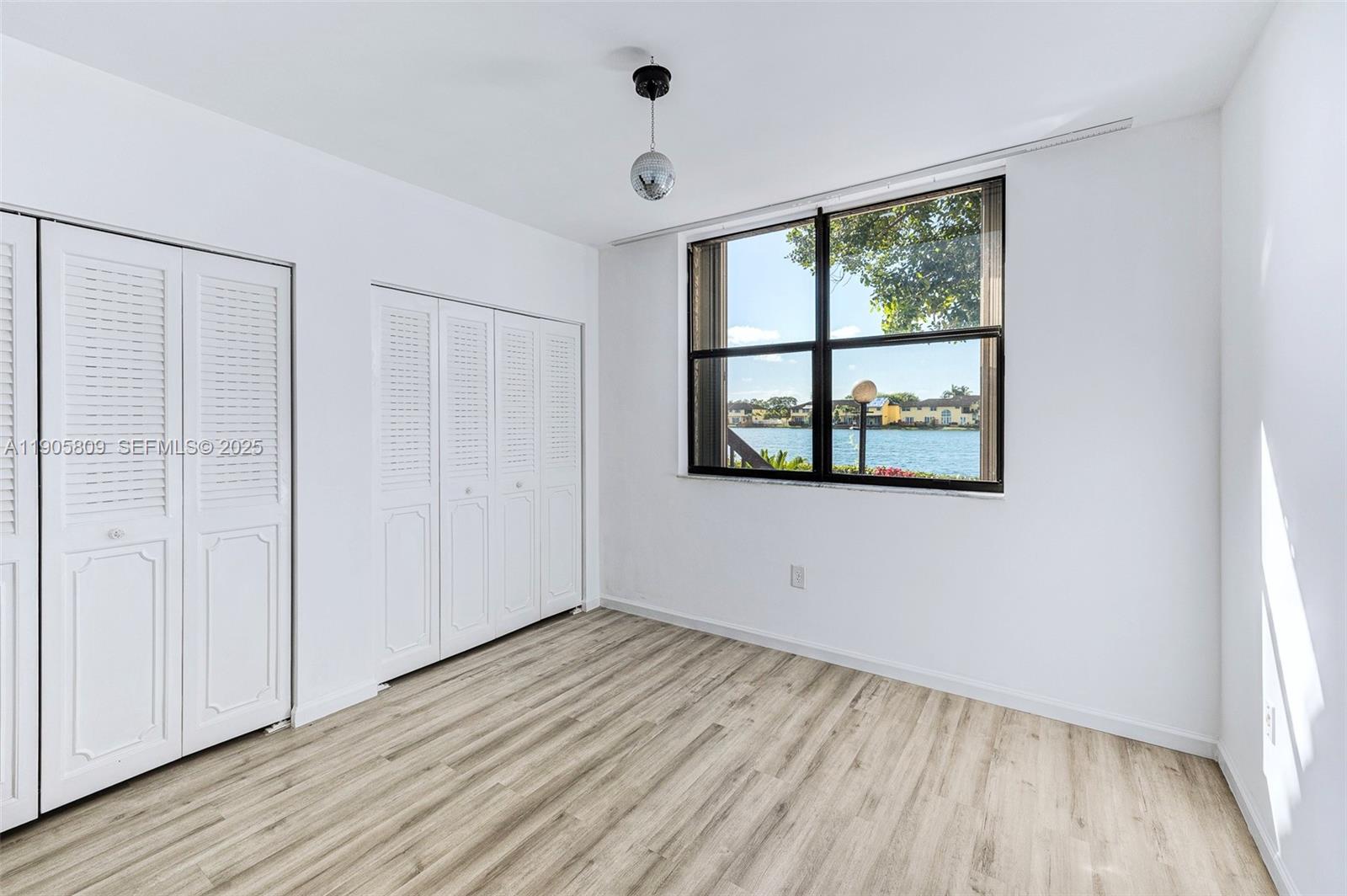 770 Northeast 199th Street, Unit 106F Miami, FL 33179 - Photo 16 of 25 an empty room with wooden floor and windows