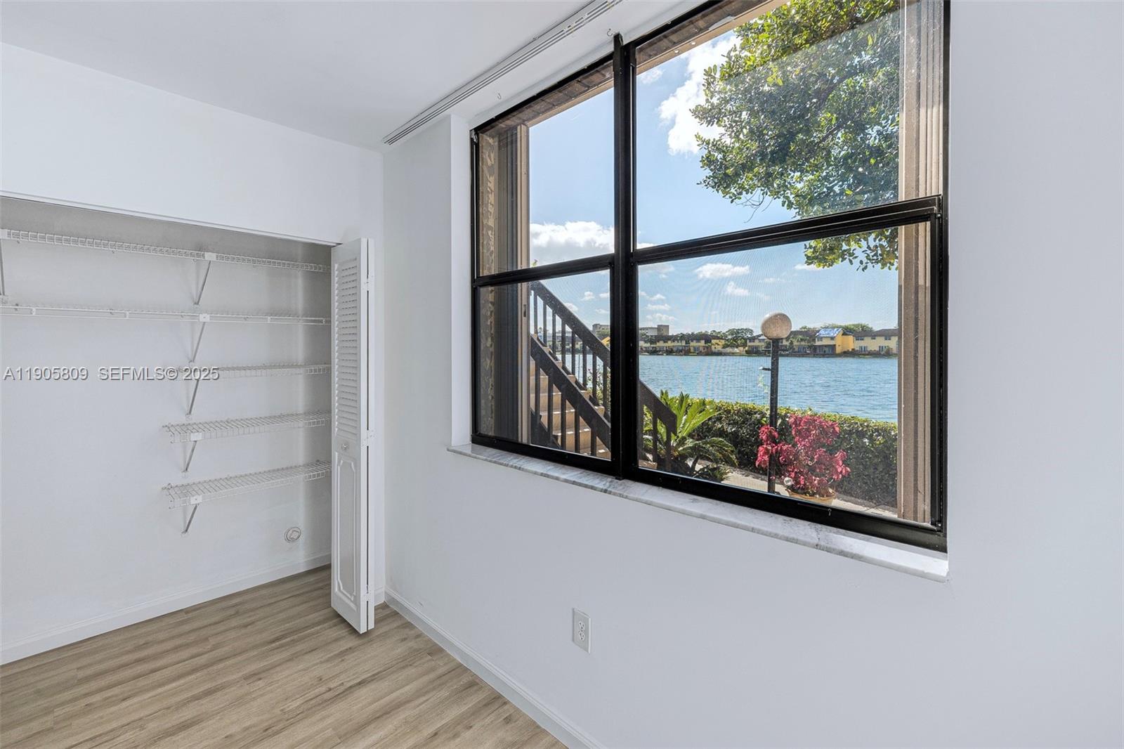 770 Northeast 199th Street, Unit 106F Miami, FL 33179 - Photo 17 of 25 an empty room with wooden floor and windows