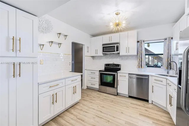 a kitchen with white cabinets and stainless steel appliances