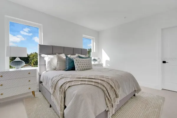 a large bed sitting in a bedroom next to a window
