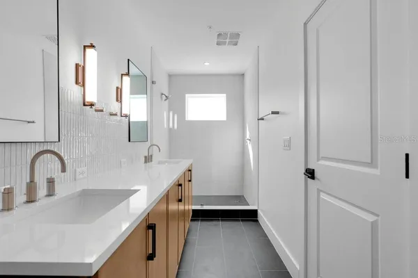 a bathroom with a double vanity sink and mirror
