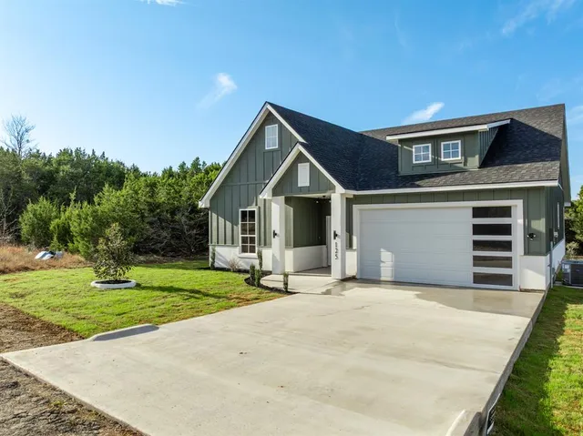 a view of a house with a yard and garage