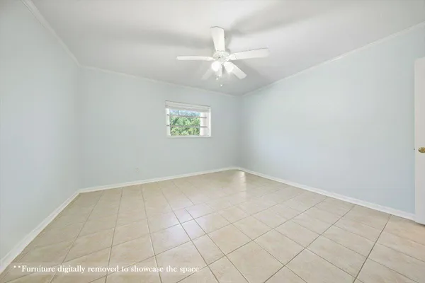 an empty room with a ceiling fan and window