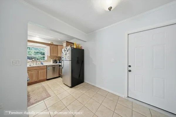 a kitchen with a refrigerator and white cabinets