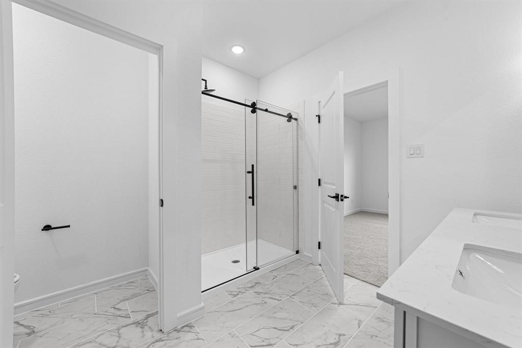 1509 Hamilton Street Howe, TX 75459 - Photo 13 of 23 Bathroom featuring baseboards, a stall shower, a sink, and marble finish floor