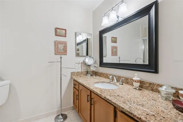 a bathroom with a granite countertop sink vanity and mirror