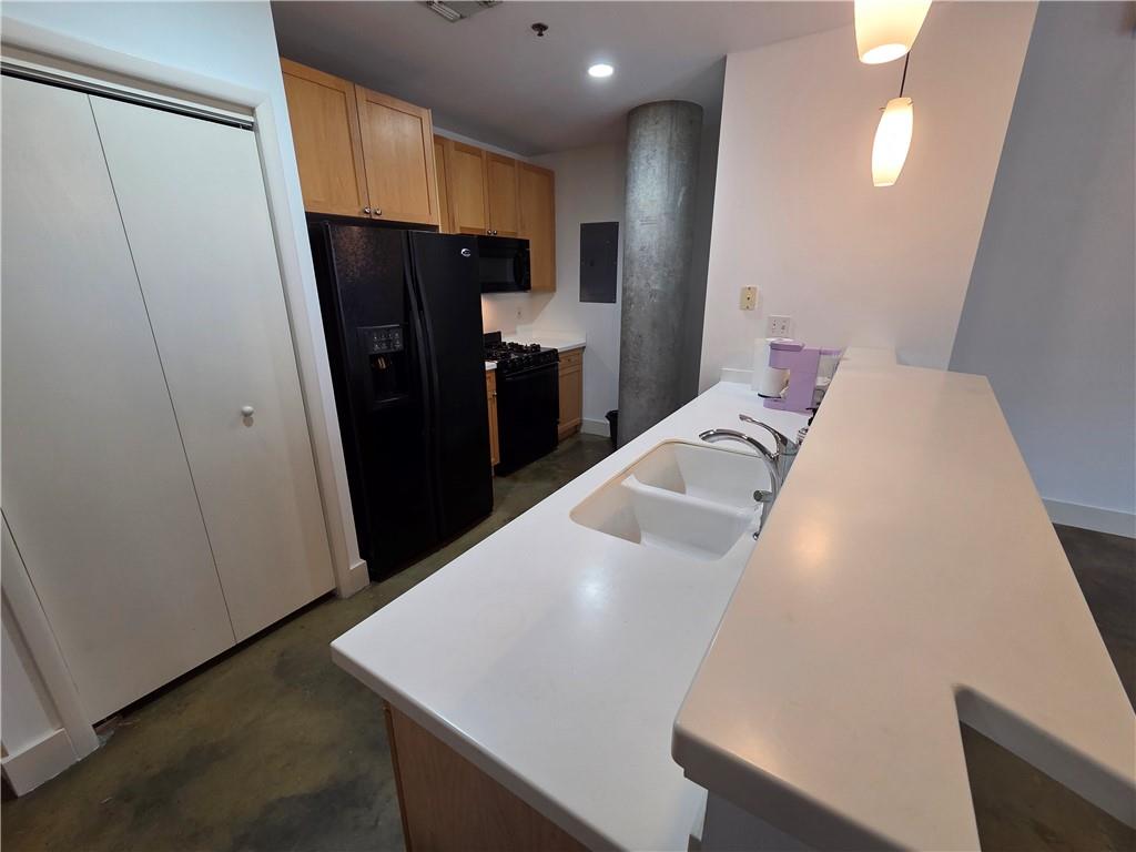 845 Spring Street Northwest, Unit 104 Atlanta, GA 30308 - Photo 12 of 40 a view of a kitchen with refrigerator and wooden floor