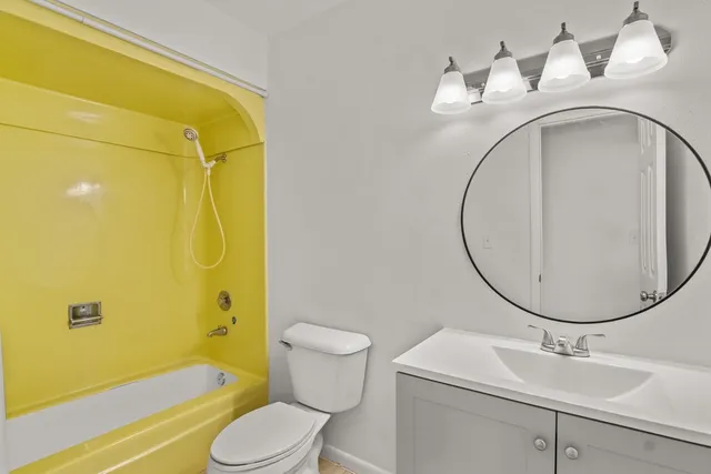 a view of an empty room with window and cabinet area