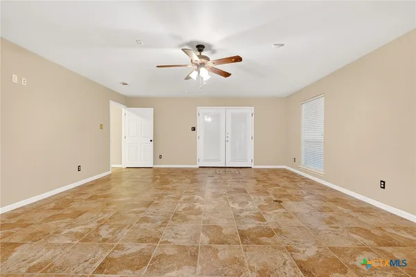 a view of an empty room with a ceiling fan
