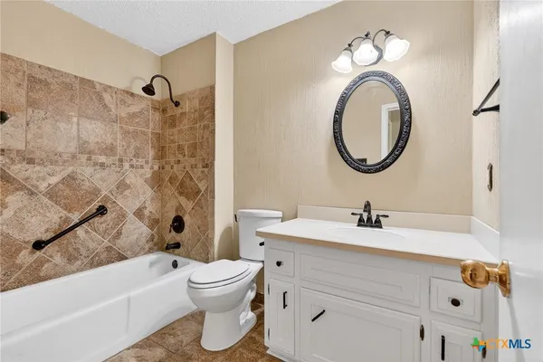 an empty room with chandelier fan and windows