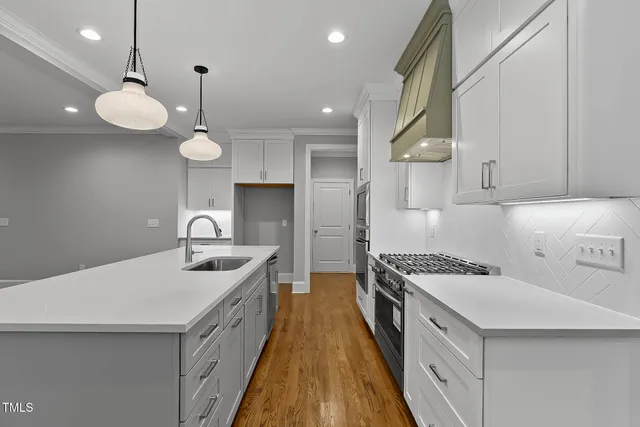 a view of a hallway with wooden floor and a bathroom