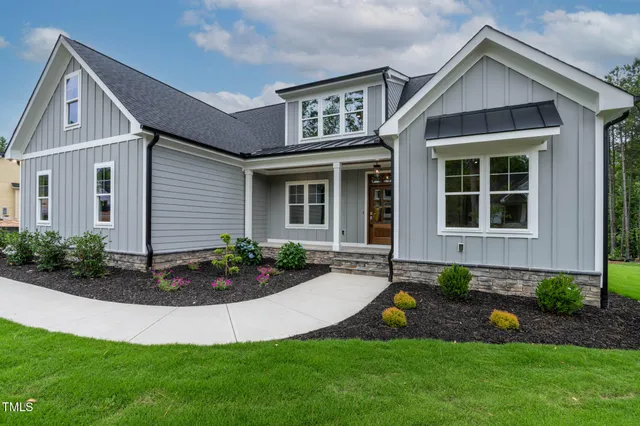 a front view of a house with a yard and trees