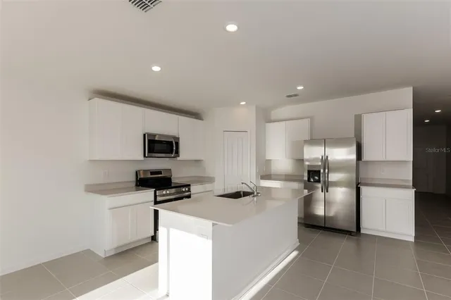 a kitchen with stainless steel appliances a refrigerator and a stove top oven