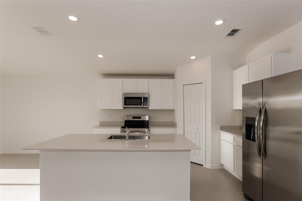 2770 Pennachio Dr Lake Lake Wales, FL 33853 - Photo 9 of 15 a kitchen with kitchen island stainless steel appliances a sink and a refrigerator