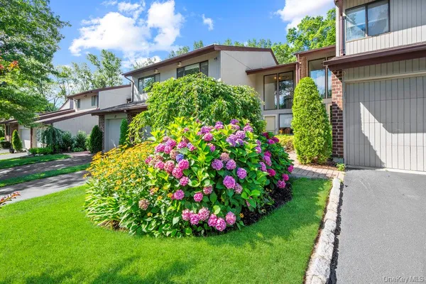 a view of a flower in a garden with a house