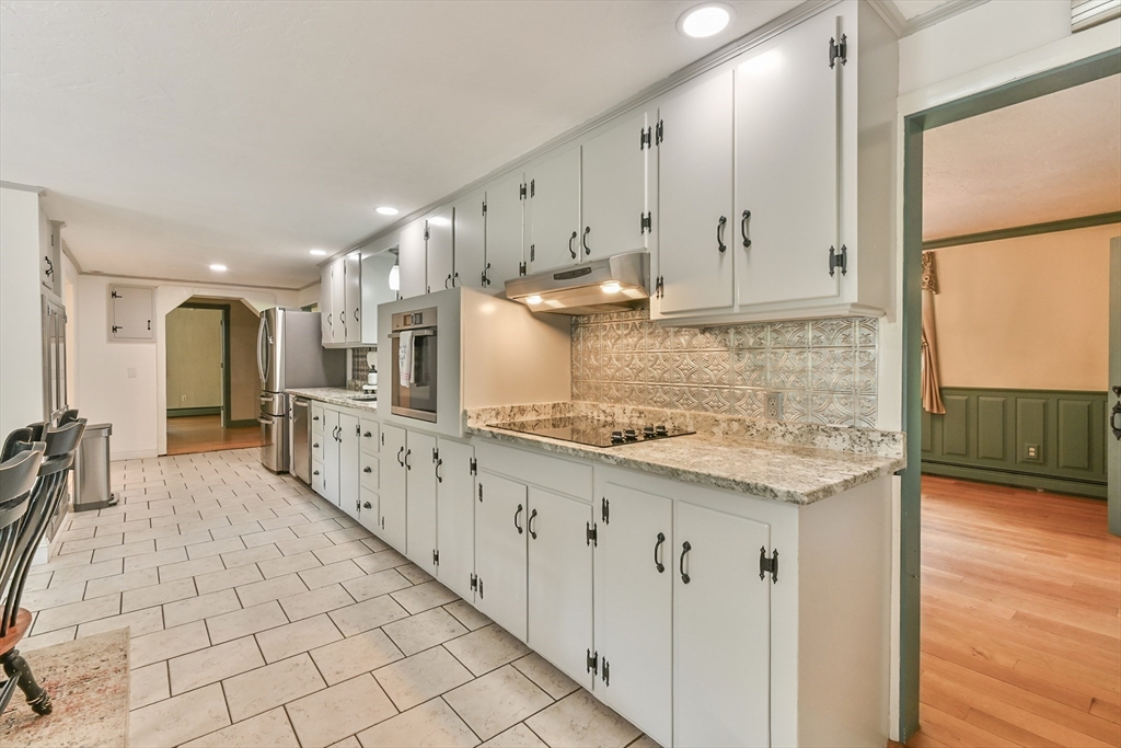 95 Charlton Road Dudley, MA 01571 - Photo 28 of 42 a kitchen with granite countertop a sink a stove top oven a counter space and cabinets
