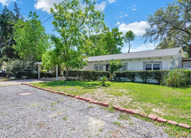 a view of a house with backyard and trees