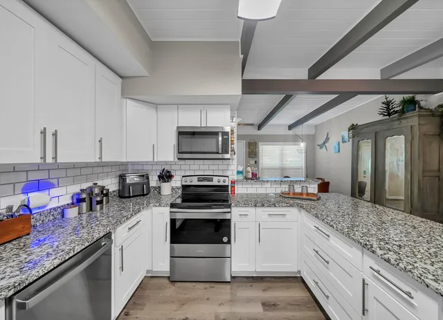 a kitchen with stainless steel appliances granite countertop a stove sink and cabinets