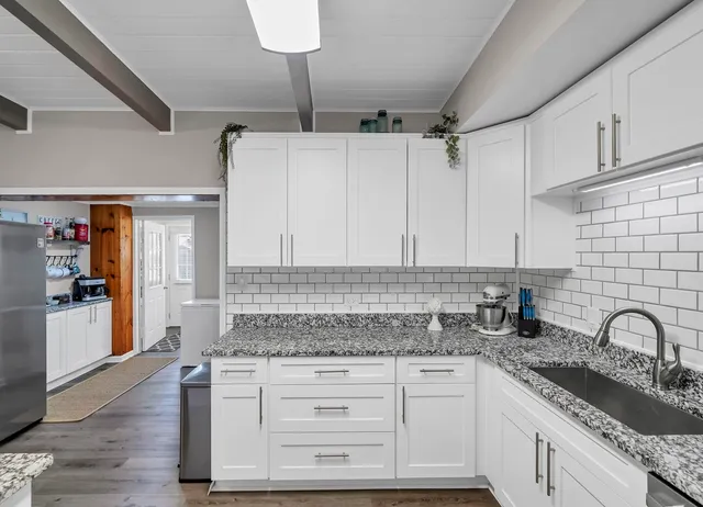 a kitchen with granite countertop a sink stainless steel appliances and cabinets