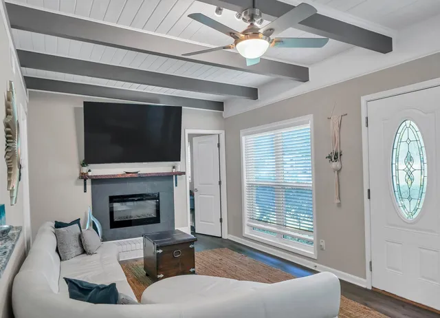 a living room with furniture a fireplace and a flat screen tv
