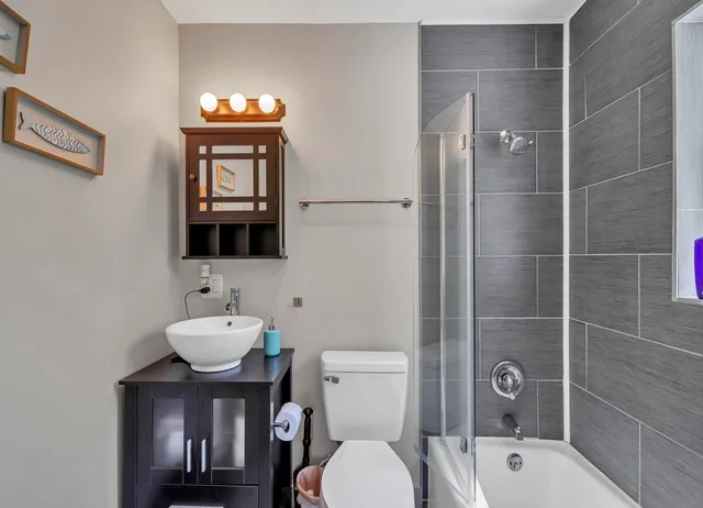 a bathroom with a toilet a sink and mirror