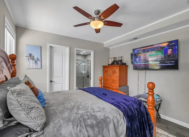 a bed room with a bed a couch and a chandelier