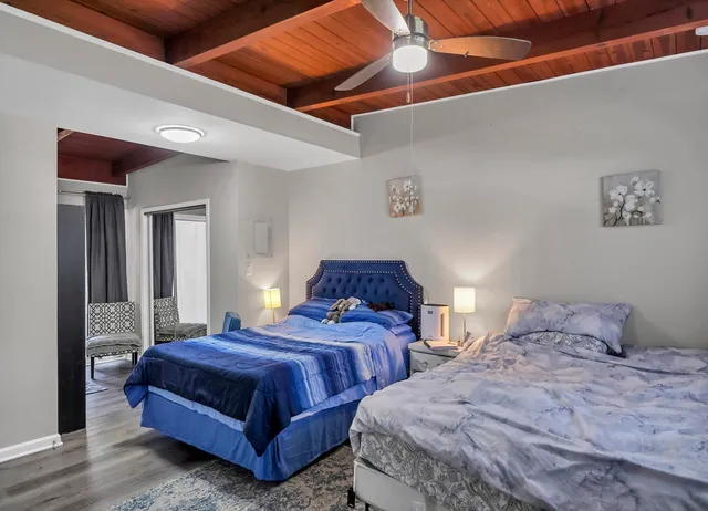 a bedroom with two beds and painting on the wall