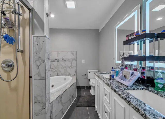 a bathroom with a granite countertop sink a mirror and shower