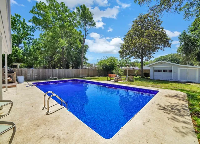 a swimming pool with outdoor seating and yard