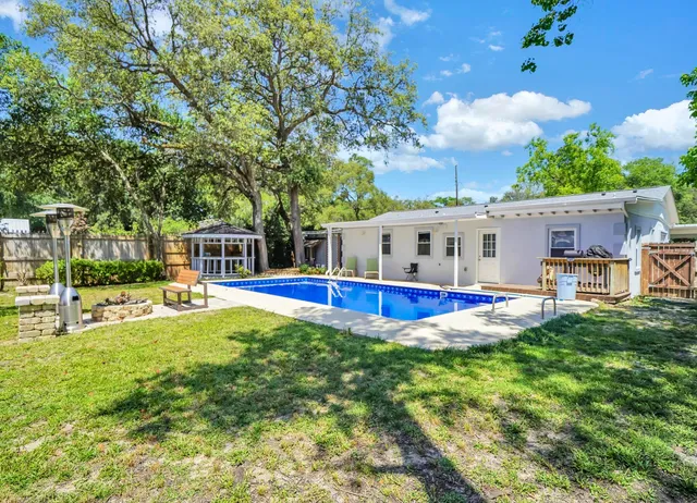 a view of a house with a big yard and sitting area