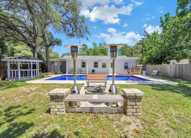 a view of swimming pool with umbrella and trees