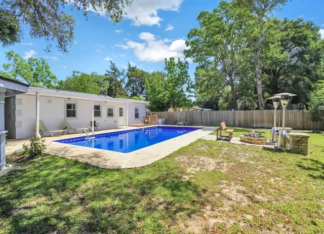 a view of a house with swimming pool and a yard