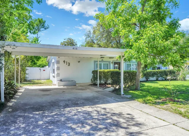 a view of a house with a yard and a garage