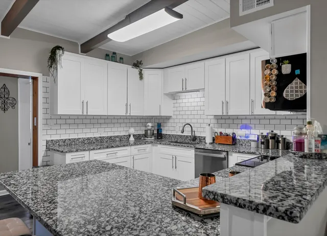 a kitchen with stainless steel appliances granite countertop a sink stove and cabinets