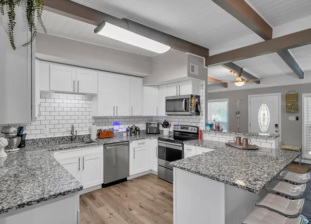 a kitchen with stainless steel appliances granite countertop a sink stove and refrigerator