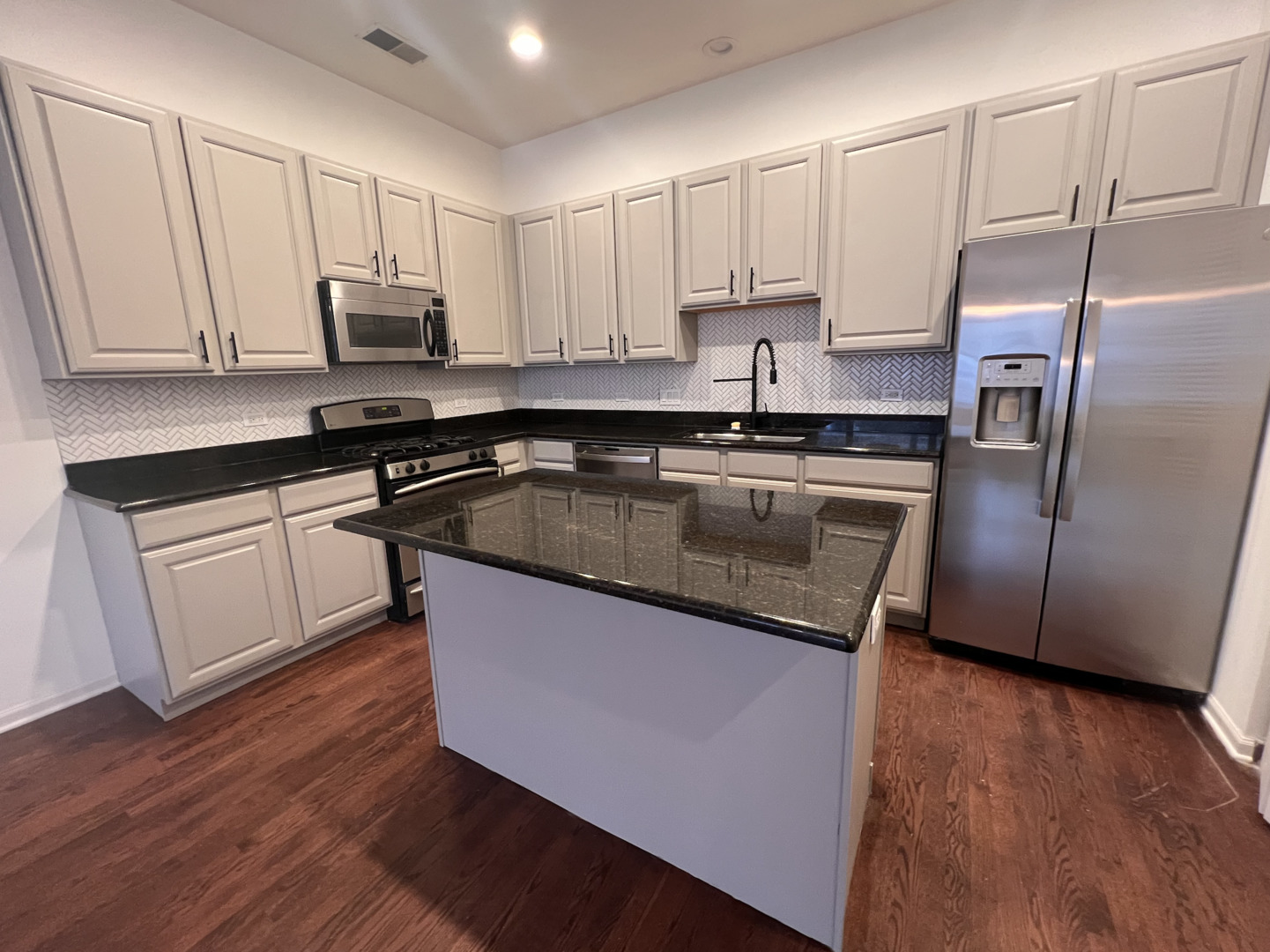 Undisclosed Address Chicago, IL 60610 - Photo 4 of 12 a kitchen with stainless steel appliances granite countertop a refrigerator a sink and white cabinets