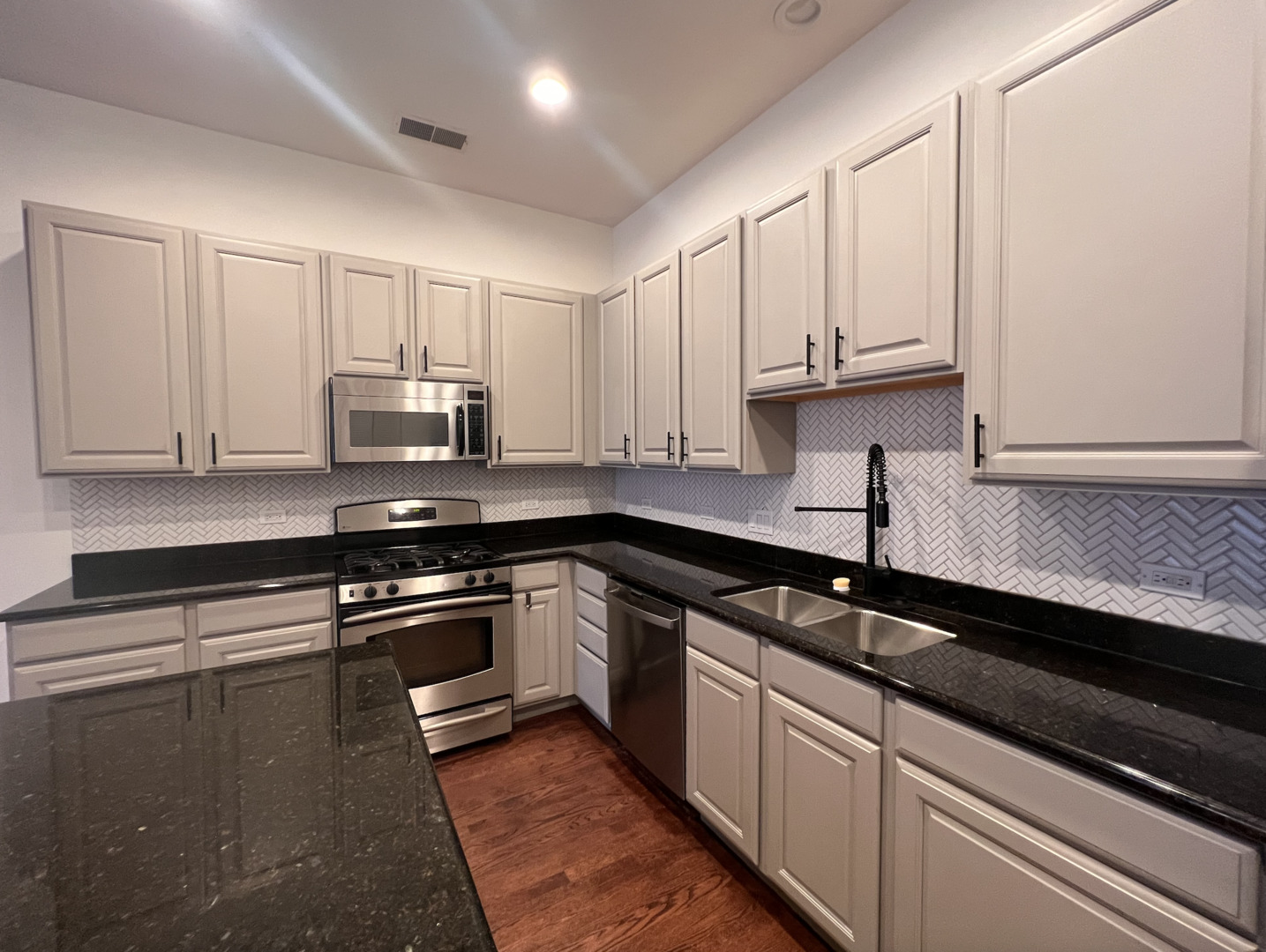 Undisclosed Address Chicago, IL 60610 - Photo 5 of 12 a kitchen with granite countertop white cabinets and black appliances