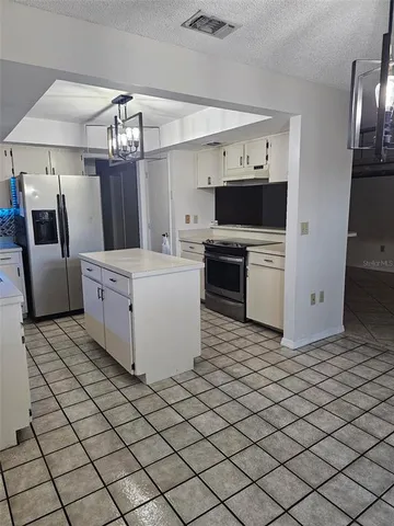 a kitchen with stainless steel appliances a refrigerator and a stove top oven