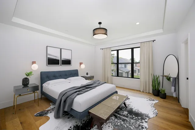 a bedroom with a bed large window and a potted plant