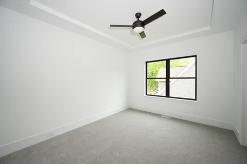 an empty room with a window and a ceiling fan