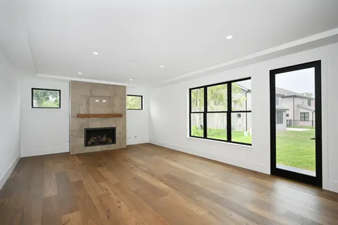 a view of an empty room with a window and a fireplace