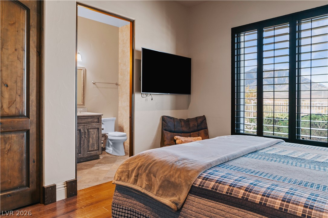1123 Christian Road Henderson, NV 89002 - Photo 32 of 94 Hardwood flooring extends into this spacious bedroom featuring shuttered windows and an adjoining private bathroom.