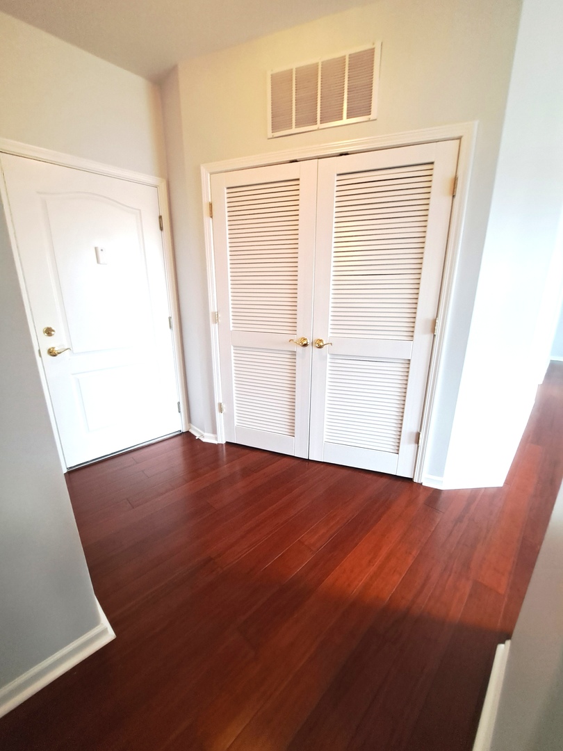 1307 West Lake Street, Unit 304 Addison, IL 60101 - Photo 8 of 33 a view of an empty room with wooden floor and a window